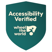 Green shield with text: Accessibility Verified, Wheel the World logo.