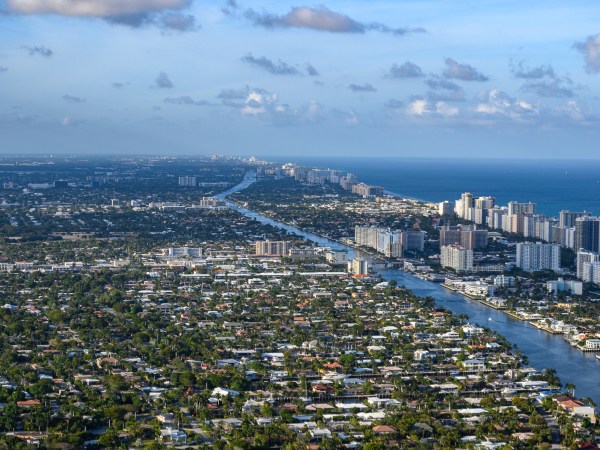 Aerial view of a coastal cityscape with high-rise buildings and waterways.