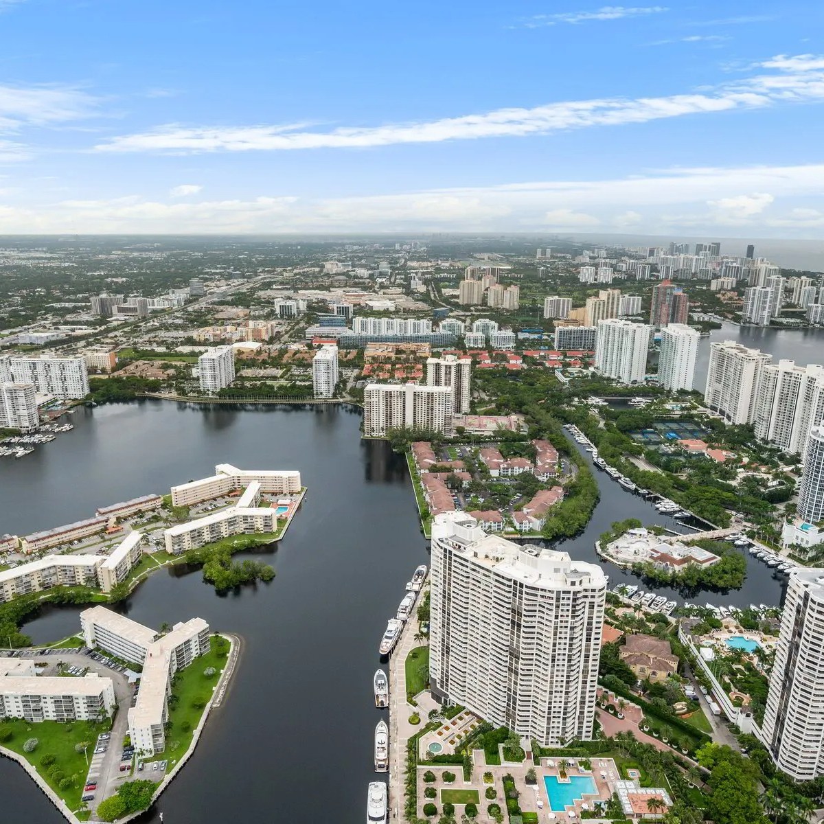 Aerial view of a city with high-rise buildings and waterways on a clear day.