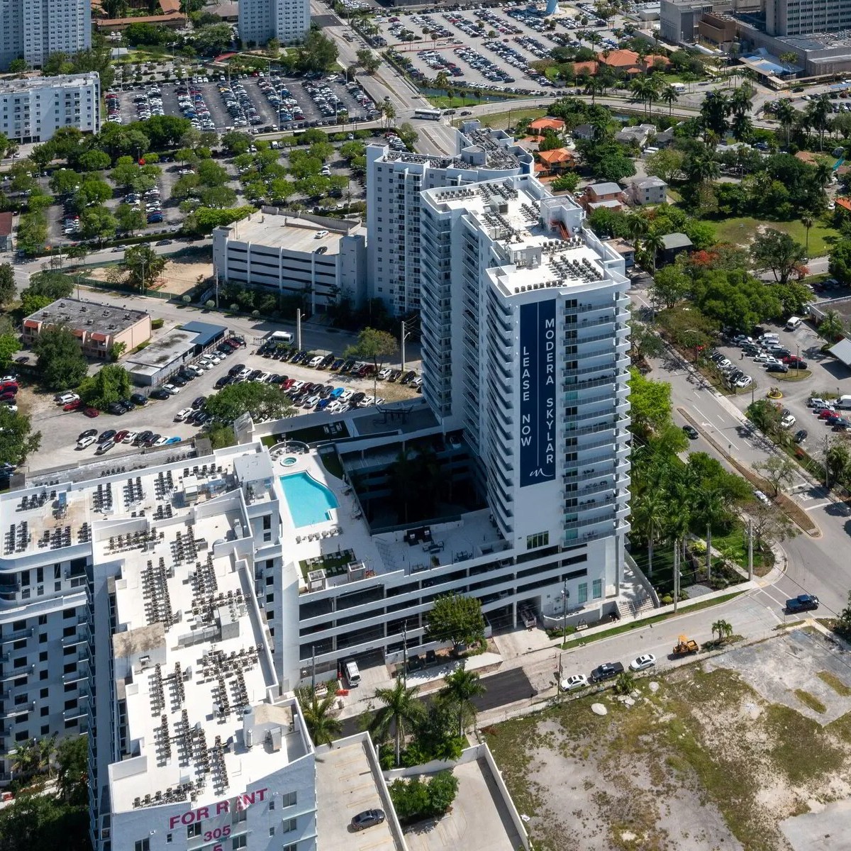 Aerial view of tall buildings with a pool in an urban area.