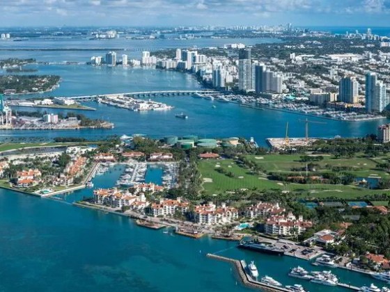 Aerial view of coastal cityscape with water, buildings, and islands.