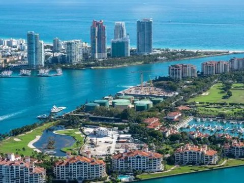 Aerial view of a coastal city with skyscrapers and water channels.