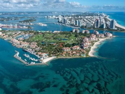 Aerial view of a coastal cityscape with islands and high-rise buildings.